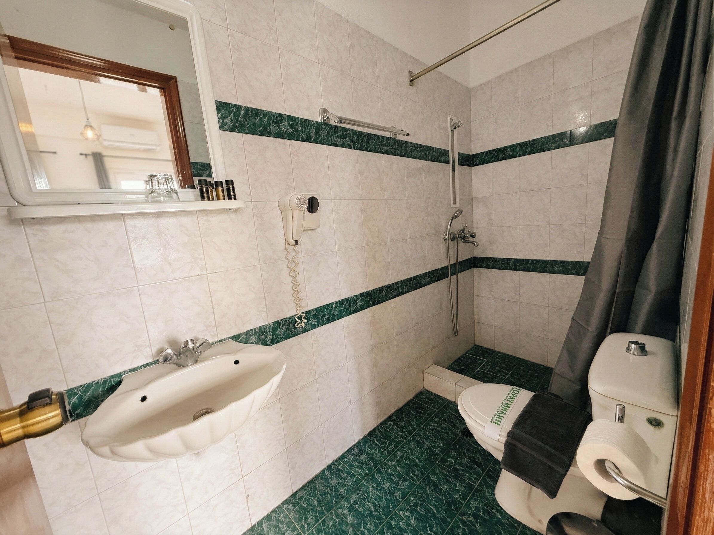 A bathroom with a sink, toilet, and shower.