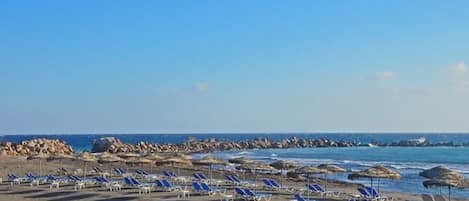 En la playa, playa de arena negra y toallas de playa