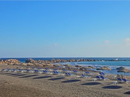 On the beach, black sand, beach towels. Aegean Nest Studios - Adults only