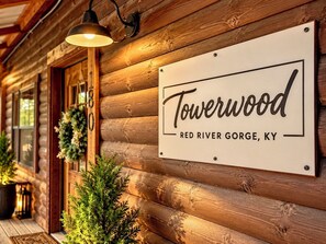 A wooden cabin with a sign reading 'Towerwood Red River Gorge, KY'. - Cozy Winter Cabin: Steamy Hot Tub, Fire Pit, Game Room, Family + Pet Friendly (Campton)