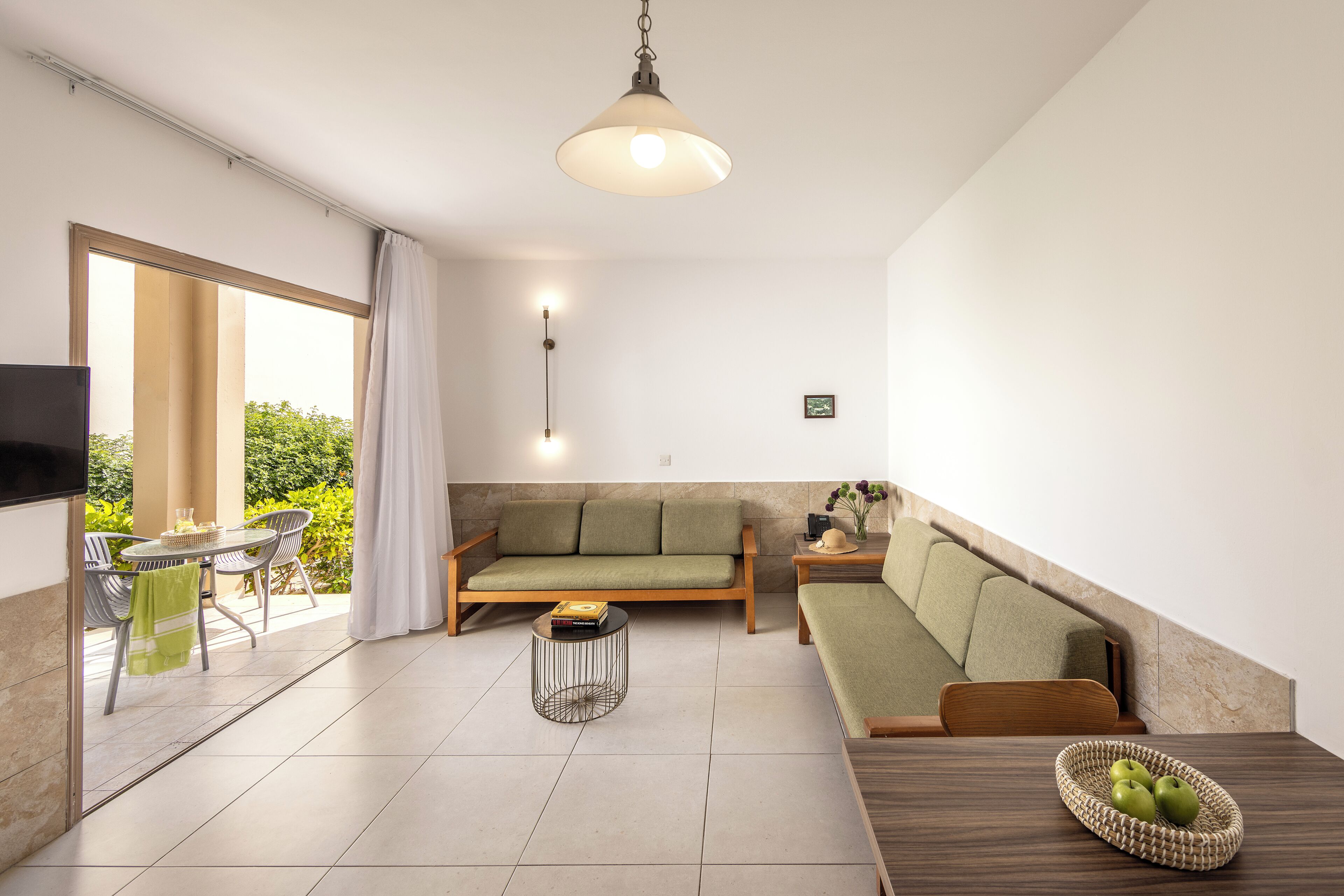 A modern living room with a sofa, a dining table, and a TV.