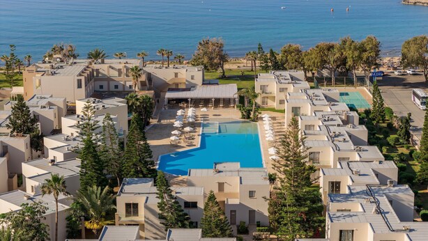 Un complexe hôtelier doté d’une piscine, de plusieurs bâtiments et offrant une vue sur la mer.
