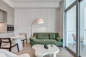 A modern living room with a green sofa, a white coffee table, and a floor lamp. - Urban Chic 1Bedroom in DEC Tower Marina (Dubai)
