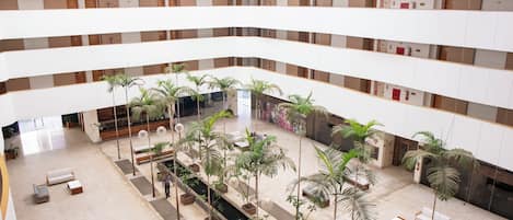 A multi-level atrium with a central water feature, multiple seating areas, and potted plants.