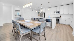A modern kitchen with white cabinets, stainless steel appliances, and a central island. - The Grove Dogwood 331 - 4 Bedrooms - Lazy River - Seascape Resort (Miramar Beach)