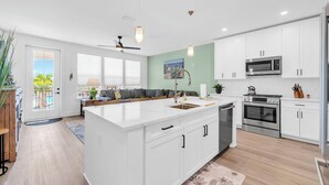 A modern kitchen with white cabinets, stainless steel appliances, and a large island. - The Grove Juniper 227 - 1 Bedroom - Lazy River - Seascape Resort (Miramar Beach)