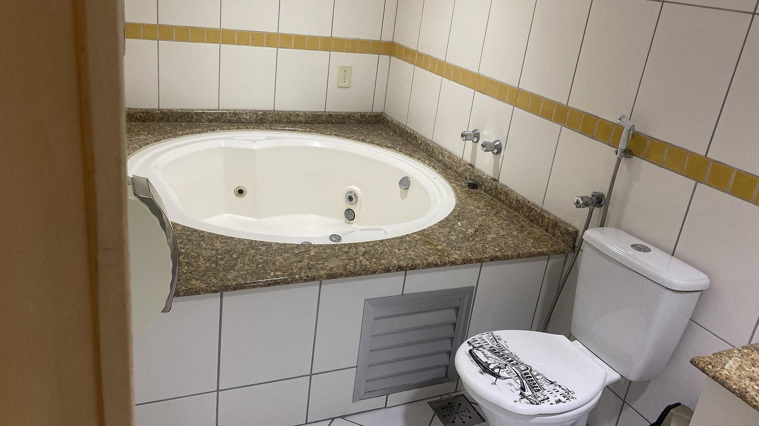 A bathroom with a bathtub, toilet, and a shower area.