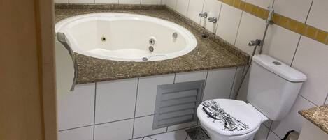 A bathroom with a bathtub, toilet, and a shower area.
