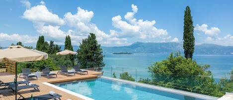 Una piscina al aire libre de temporada, sombrillas
