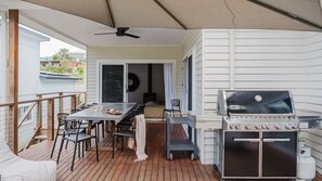 An outdoor deck with a grill, dining table, and chairs. - The Lake Escape - Sauna & Spa (Conjola Park)