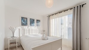 Una camera da letto moderna con un letto grande, comodini e opere d'arte appese al muro.