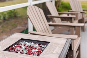 A patio area with Adirondack chairs and a square table with a glass top. - 3-bedroom house in perfect Rotonda West with cool AC (Rotonda West)
