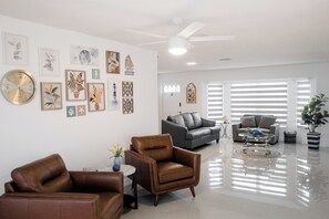 A modern living room with leather sofas, a coffee table, and wall art. - 3-bedroom house in perfect Rotonda West with cool AC (Rotonda West)