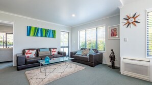 Un salon moderne avec deux canapés, une table basse en verre et un tapis décoratif.