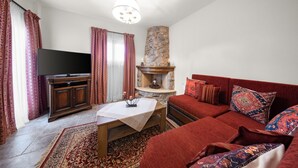 Ein Wohnzimmer mit Fernseher, Sofa und Kamin.
