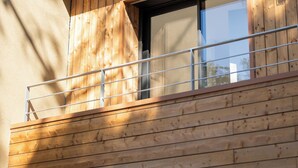 A wooden exterior of a building with a balcony and a window. - Villa Cala Rossa (Lecci)