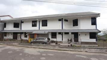 A two-story building with a grey roof and white walls.
