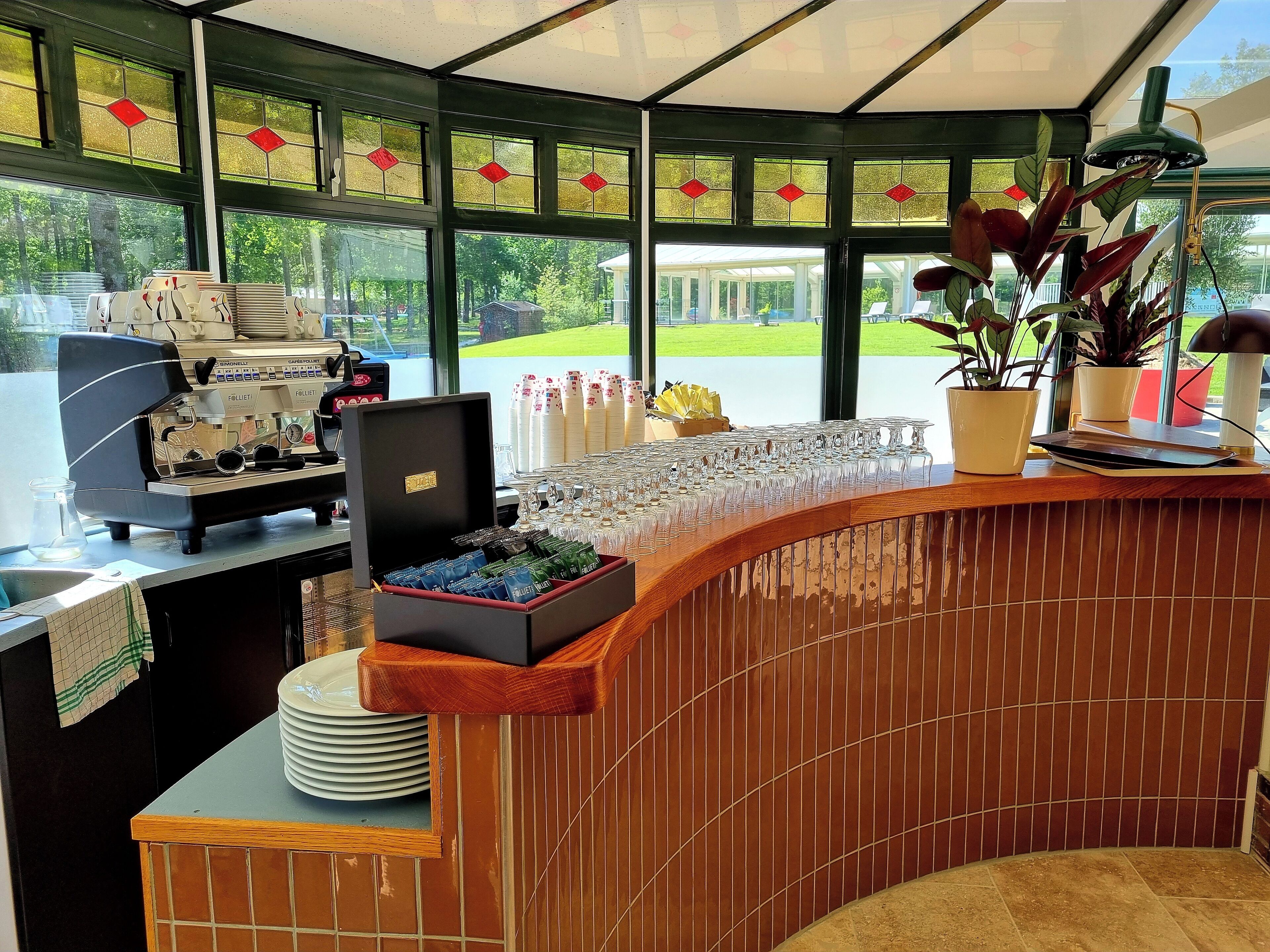 Un café doté d’une machine à café, d’une vitrine réfrigérée et offrant une vue sur l’extérieur.
