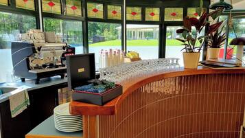 Un café doté d’une machine à café, d’une vitrine réfrigérée et offrant une vue sur l’extérieur.