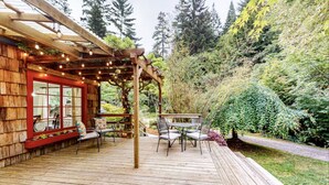 A wooden deck with outdoor seating and string lights. - Lucky Clover over the Covered Bridge (Eureka)