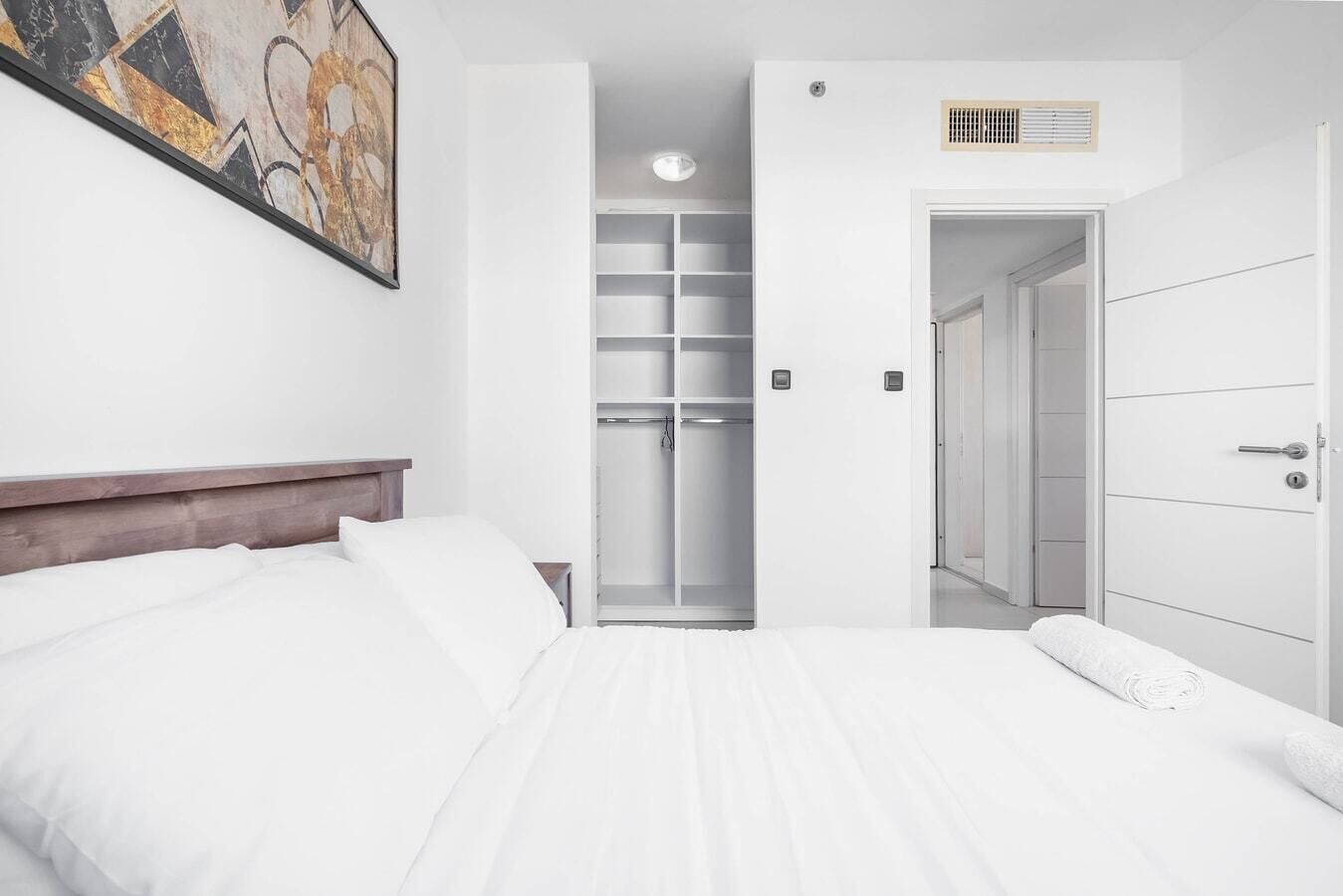 A hotel room with a bed, a wardrobe, and a walk-in closet.