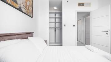 A hotel room with a bed, a wardrobe, and a walk-in closet.