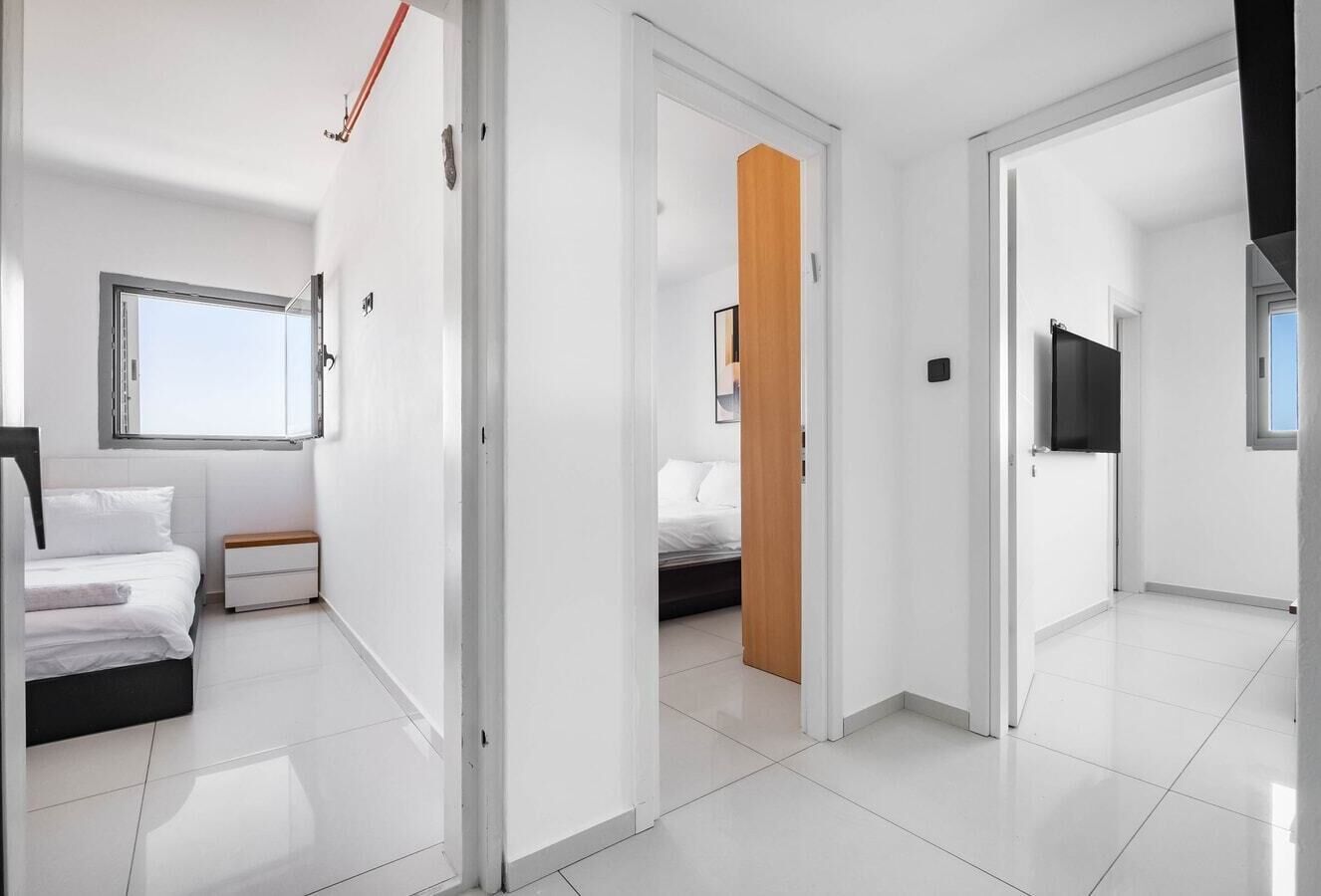 Ein modernes Hotelzimmer mit Bett, Nachttisch und Fernseher.