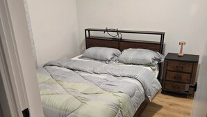 Un dormitorio con cama, mesita de noche y cómoda.