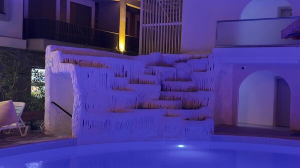 A pool with a unique ice-like structure, a balcony, and a door leading to an outdoor area. - Rayon Apart hotel (Marmaris)