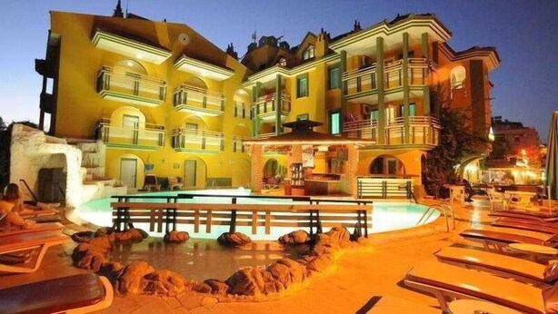 A hotel with a pool area, multiple balconies, and outdoor seating. - Rayon Apart hotel (Marmaris)