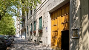 A street with parked cars, a building with a large wooden door, and a sign indicating no parking. - GuestHost - Milanese Mountain Escape x5 (Milano)