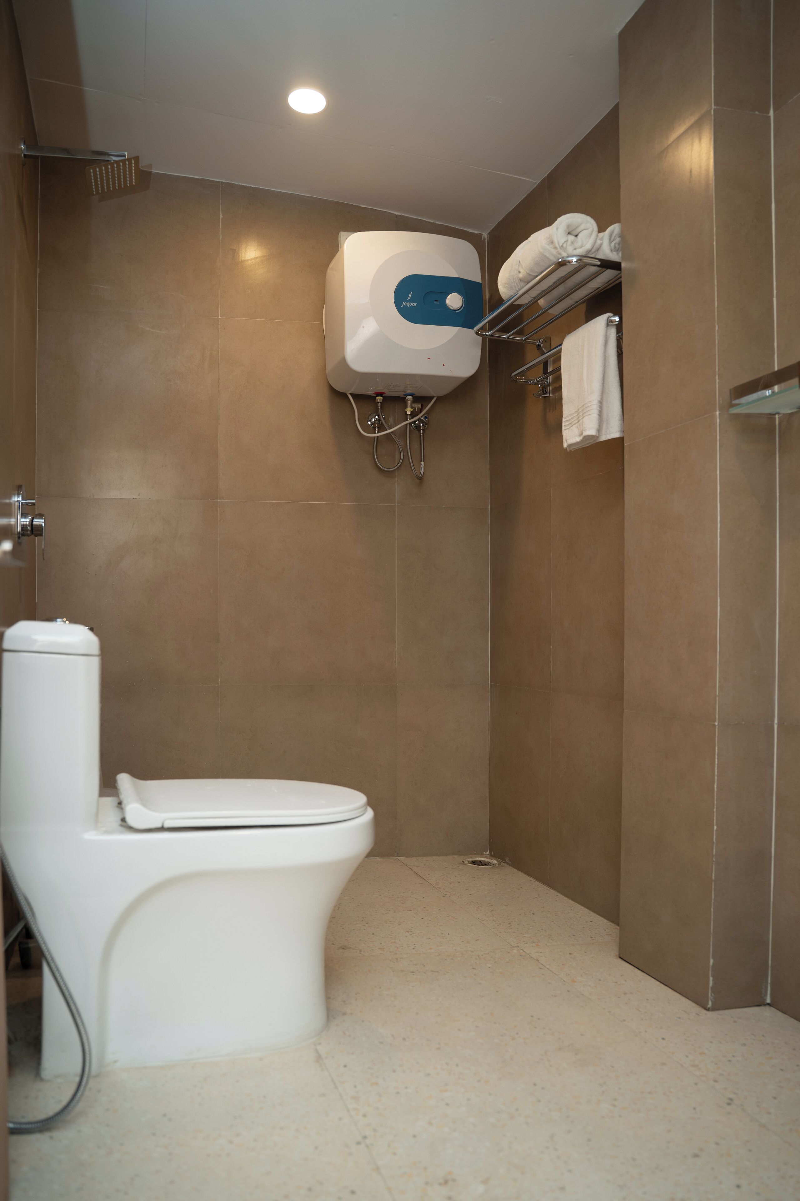 Un bagno moderno con il water, un bidet a muro e un porta asciugamani.