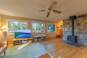 A living room with a television, stone fireplace, and large windows. - Bakersfield Basecamp - Meyers Escape (South Lake Tahoe)