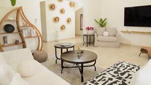 A modern living room with a sofa, coffee table, and a TV mounted on the wall. - Casa Verde: Grand Case Village (Grand-Case)