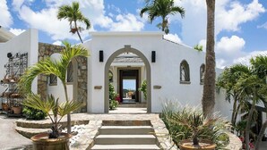Un edificio con fachada de piedra, entrada en arco y escalones que conducen a una puerta.