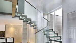 Eine moderne Treppe mit Glasgeländern und einem Wasserspiel.
