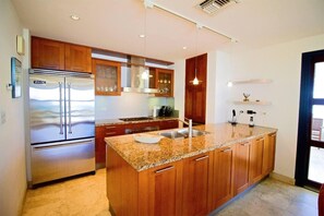 Eine moderne Küche mit Holzausstattung, Edelstahlgeräten und einer Arbeitsplatte aus Granit.