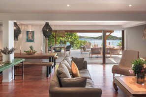 A spacious living area with a large sofa, a dining table, and a view of the sea. - Baltazar   Idyllic Sunrises & Stunning ocean views (Cul-de-Sac)