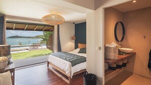 Ein Schlafzimmer mit einem großen Fenster mit Blick auf einen Pool und das Meer.