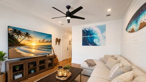 A living room with a TV, a sofa, a coffee table, and artwork on the walls. - Luxury 3-Level Townhome Santa Rosa Beach Florida 30A, Walk2Beach, Golf Cart,Pool (Santa Rosa Beach)