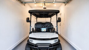 A white golf cart with a black roof parked in a garage. - Luxury 3-Level Townhome Santa Rosa Beach Florida 30A, Walk2Beach, Golf Cart,Pool (Santa Rosa Beach)