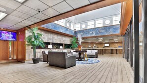 Eine geräumige Lobby mit hoher Decke, Holzböden und einem Empfangstresen.