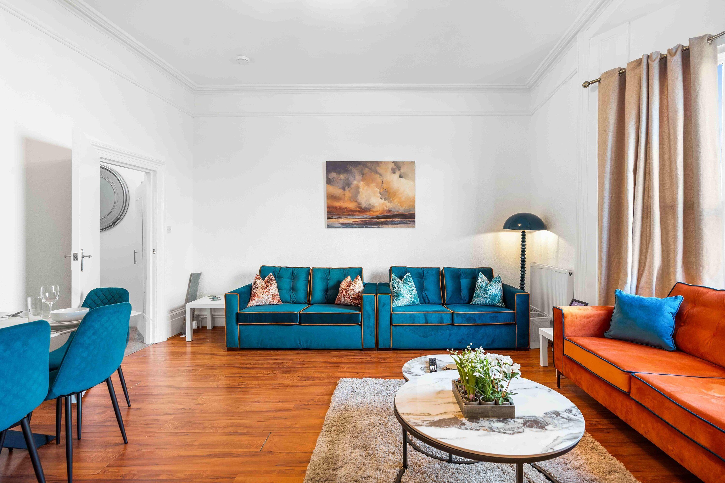 Una sala de estar con dos sofás, una mesa de centro y un comedor.