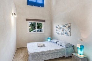 A bedroom with a bed, a window, a wall-mounted artwork, and bedside lamps. - Josade Blu Mare Apartment with Sea View, Wi-Fi, and Air Conditioning (Alcamo)