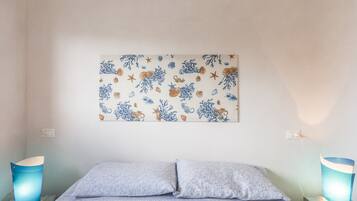 Una camera da letto con un letto, due lampade da comodino e un'opera d'arte appesa al muro.