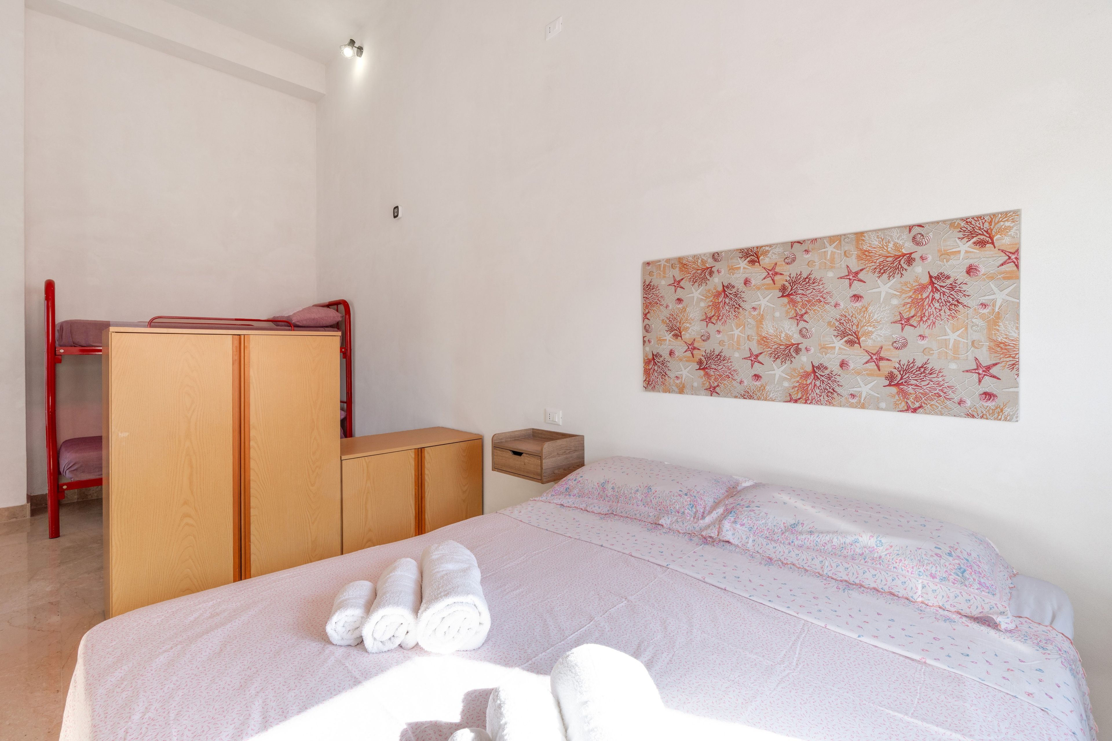 Een slaapkamer met een bed, een bureau en een kledingkast.