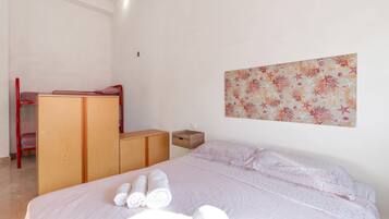 Een slaapkamer met een bed, een bureau en een kledingkast.