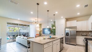 A modern kitchen with a large island, stainless steel appliances, and pendant lighting. - 5BR Solterra Villa, Pool & Jacuzzi (Davenport)