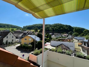 Un quartier résidentiel avec des maisons, un ciel dégagé et une colline en arrière-plan.