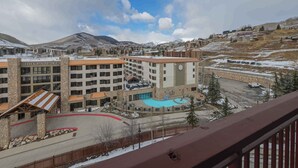 A hotel with multiple floors, a swimming pool, and a mountainous backdrop. - Luxury 2-Bed Penthouse w/ Home Office (Crested Butte)